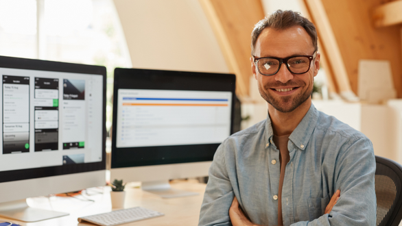 Happy male in front of his computer work station